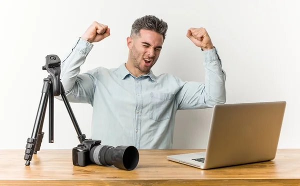 Young handsome photography teacher raising fist after a victory, winner concept.