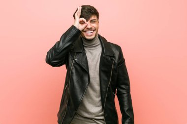 Deri ceket giyen genç İspanyol adam göz ok jest tutmak heyecanlı.