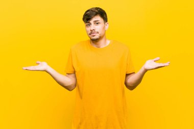 Genç İspanyol rahat adam şüphe ve sorgulama jest omuzsa.