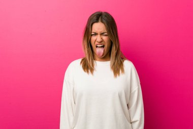 Bir duvara karşı genç otantik karizmatik gerçek insanlar kadın komik ve dostu dil dışarı yapışmasını.