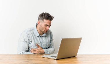 Onun laptop hasta ile çalışan genç yakışıklı adam, stomachache muzdarip, ağrılı hastalık kavramı.