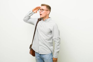 Genç kafkas iş adamı uzaklara bakıyor el ele alnına bakıyor.