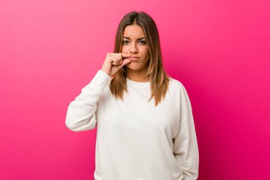 Dudaklarında parmakları ile bir duvara karşı genç otantik karizmatik gerçek insanlar kadın bir sır tutmak.