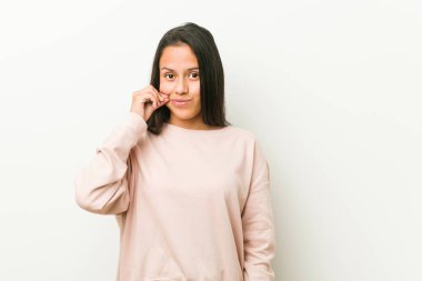 Dudaklar üzerinde parmaklar ile genç sevimli İspanyol Genç kadın bir gizli tutmak.