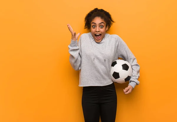 勝利または成功を祝う若いフィットネス黒人女性 サッカーボールを持つ — ストック写真