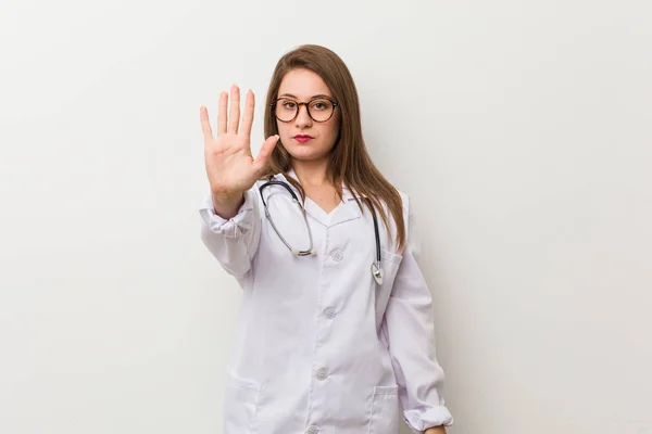 Jovem Médica Mulher Contra Uma Parede Branca Com Mão Estendida — Fotografia de Stock