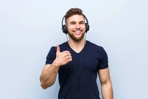 Mladý Kavkazský Muž Který Poslouchá Hudbu Usmívá Zvedá Palec — Stock fotografie