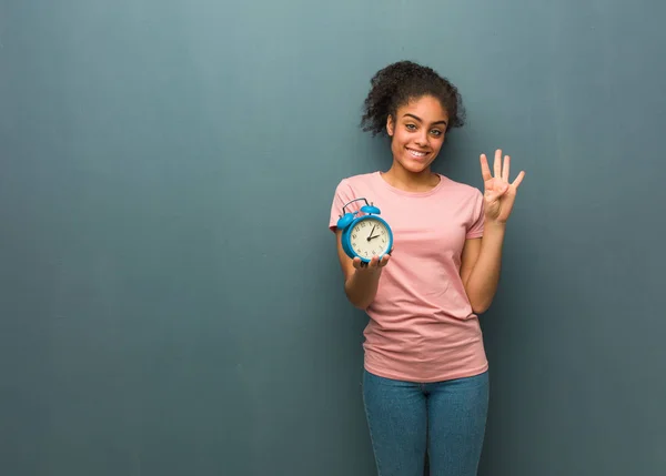 Jonge Zwarte Vrouw Toont Nummer Vier Houdt Een Wekker — Stockfoto