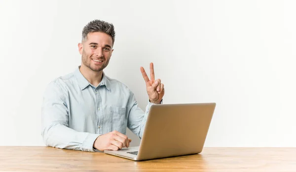 Jovem Homem Bonito Trabalhando Com Seu Laptop Mostrando Sinal Vitória — Fotografia de Stock