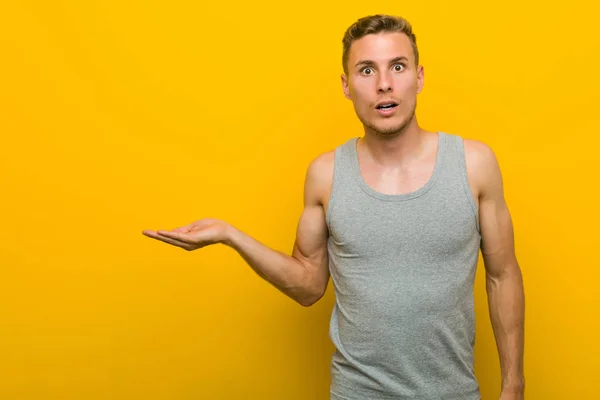 Joven Caucásico Deporte Hombre Impresionado Holding Copia Espacio Palma — Foto de Stock