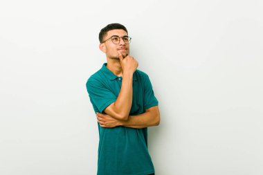 Genç İspanyol adam şüpheli ve şüpheci ifade yan bakıyor.