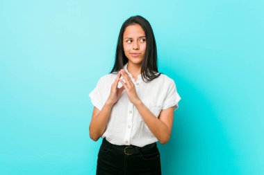 Bir fikir kurma, akılda plan yapma mavi bir duvara karşı genç İspanyol Cool kadın.