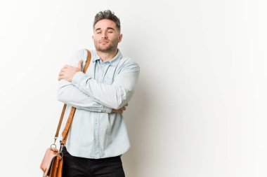 Genç yakışıklı iş adamı sarılıyor, kaygısız ve mutlu gülümseyen.