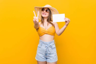 Alışverişe giden genç beyaz kadın bir pankartla sahile gitmeye hazır beyaz kadın