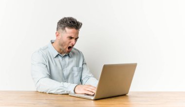 Onun laptop ile çalışan genç yakışıklı adam çok öfkeli ve agresif çığlık.