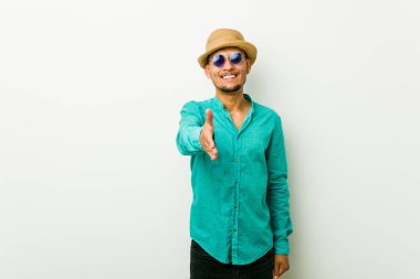 Genç İspanyol adam bir yaz giysi tebrik jest kamera el germe giyiyor.