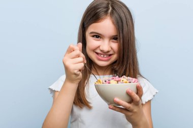 Küçük beyaz kız bir tahıl kase tutan