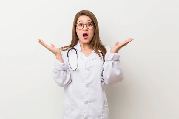 Jonge Dokter Vrouw Tegen Een Witte Muur Verrast Geschokt — Stockfoto