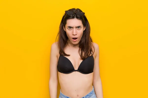 Sarı Arka Plana Karşı Bir Bikini Giyen Genç Esmer Kadın — Stok fotoğraf