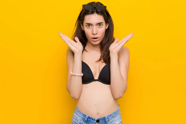 Młoda Brunetka Kobieta Ubrana Bikini Przed Żółtym Tle Zaskoczony Wstrząśnięty — Zdjęcie stockowe