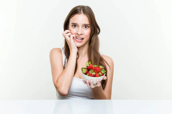 Giovane Donna Caucasica Possesso Una Ciotola Fragole Mordere Unghie Nervoso — Foto Stock