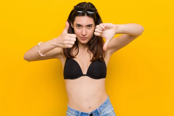 Młoda Kobieta Brunetka Ubrana Bikini Przed Żółtym Tłem Pokazując Kciuki — Zdjęcie stockowe