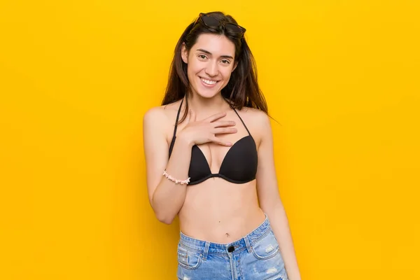 Młoda Brunetka Kobieta Ubrana Bikini Przeciwko Żółtym Tle Śmieje Się — Zdjęcie stockowe