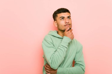 Genç İspanyol spor adam şüpheli ve şüpheci ifade ile yan bakıyor.