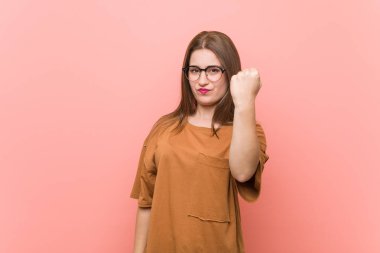 Kameraya yumruk gösteren gözlük takan genç öğrenci kadın, saldırgan yüz ifadesi.