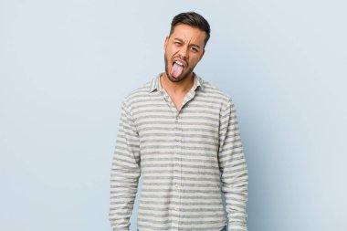 Genç yakışıklı filipinli adam komik ve dost dil dışarı yapışmasını.