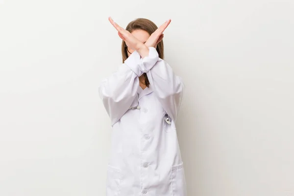 Jovem Médica Mulher Contra Uma Parede Branca Mantendo Dois Braços — Fotografia de Stock