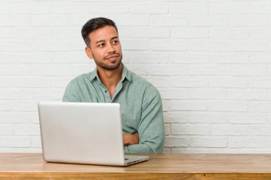 Genç filipinli adam onun laptop ile çalışan otururken çapraz kolları ile emin gülümseyerek.