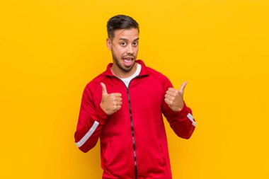 Genç filipinli fitness adam, gülümseyen ve kendinden emin her iki başparmak yükselterek.