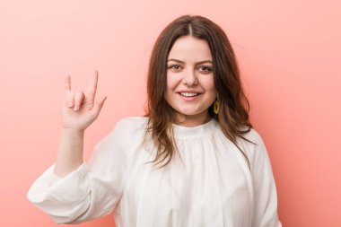 Pembe arka planda Genç beyaz Curvy kadın ayakta