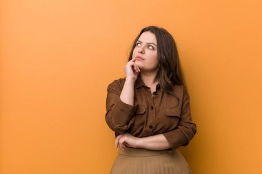 Genç Curvy Rus kadın şüpheli ve şüpheci ifade ile yan bakıyor.