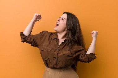 Genç kıvrımlı Rus kadın bir zaferden sonra yumruk yükselterek, kazanan kavramı.