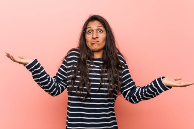 Genç entelektüel hintli kadın şüphe ve sorgulama jest onu omuzsilke.