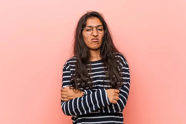 Young intellectual indian woman unhappy looking in camera with sarcastic expression.