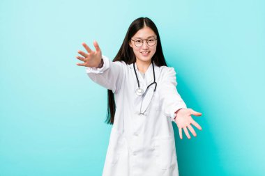 Genç Çinli doktor kadın kameraya sarılarak kendinden emin hissediyor.