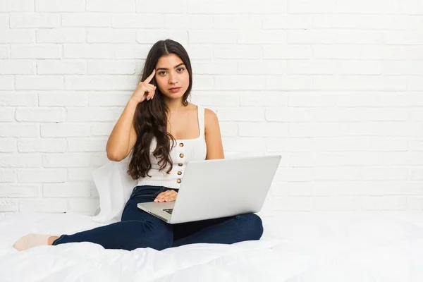 Jonge Arabische Vrouw Werken Met Haar Laptop Bed Pointing Tempel — Stockfoto