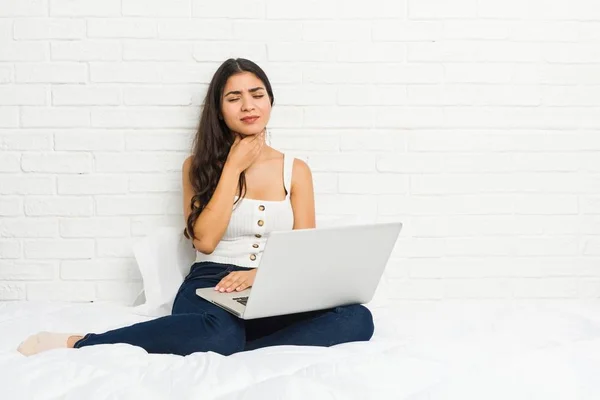 침대에서 그녀의 노트북으로 일하는 여성은 바이러스 감염으로 인후통통증을 겪습니다 — 스톡 사진