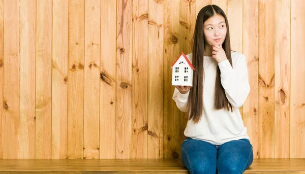Joven Mujer Asiática Sosteniendo Icono Casa Mirando Lado Con Expresión — Foto de Stock