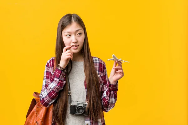 Young Asian Woman Holding Airplane Icon Relaxed Thinking Something Looking — Stock Photo, Image