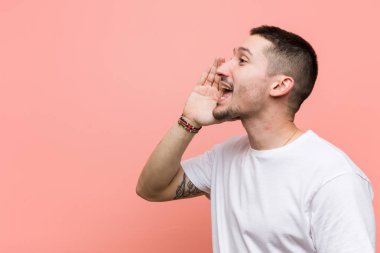 Genç rahat adam bağırıyor ve açık ağız yakınında palmiye tutarak.