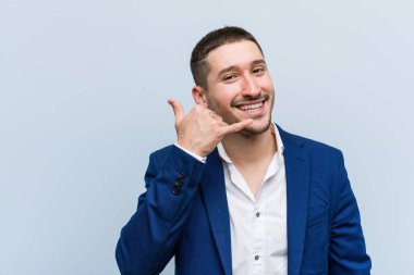 Genç iş beyaz adam parmakları ile bir cep telefonu arama jesti gösteren.