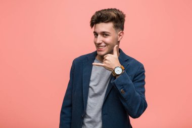 Genç iş doğal adam parmakları ile bir cep telefonu arama jesti gösteren.