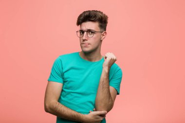 Genç serin beyaz adam başının arkasına dokunarak, düşünme ve bir seçim yapma.