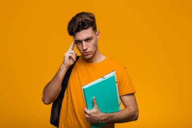 Bir dedikodu dinlemeye çalışan kitap tutan genç öğrenci adam.