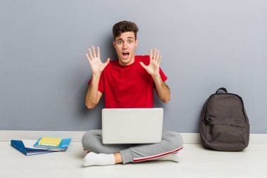 Genç genç adam oturan ve bir zafer ya da başarı kutlayan dizüstü bilgisayar ile çalışan, o şaşırır ve şok.