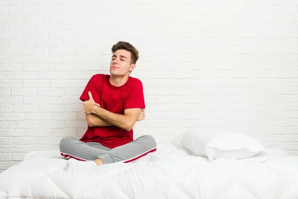 Yatakta Genç Genç Öğrenci Adam Kucaklıyor Kaygısız Mutlu Gülümsüyor — Stok fotoğraf